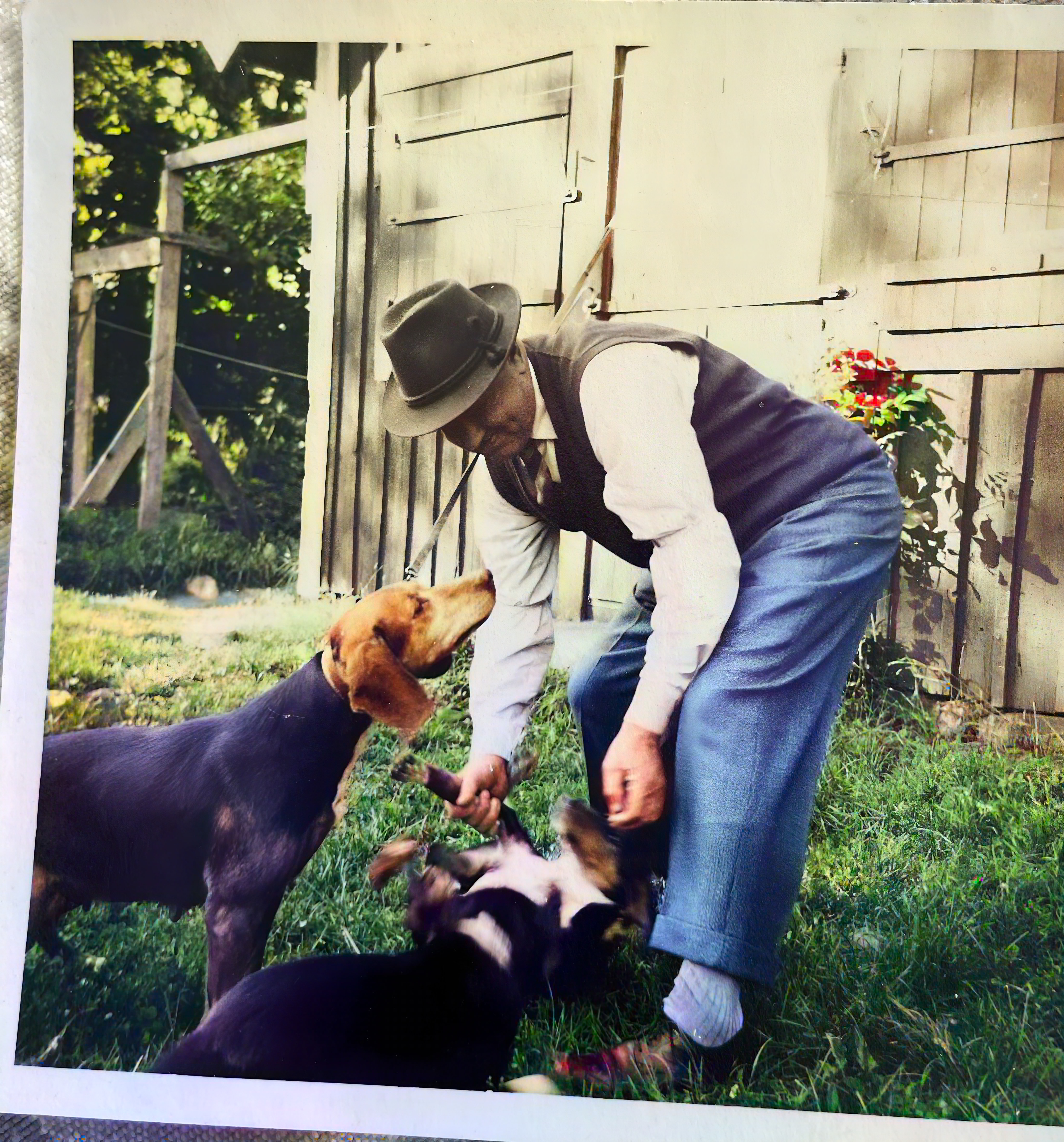 Man sittande med hund vid hus